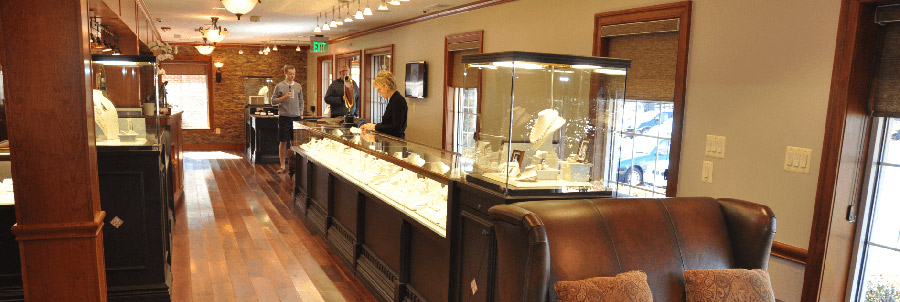 Val Adeler behind the jewelry case with customers