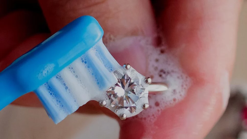 Diamond being cleaned with a toothbrush: How to lean diamond jewelry