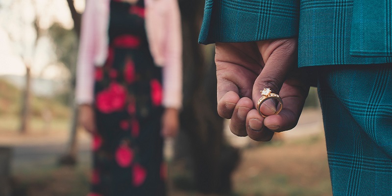 Man holding ring to propose to girlfriend.